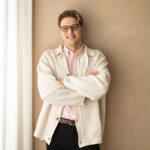 Junger Mann mit Brille lächelt.